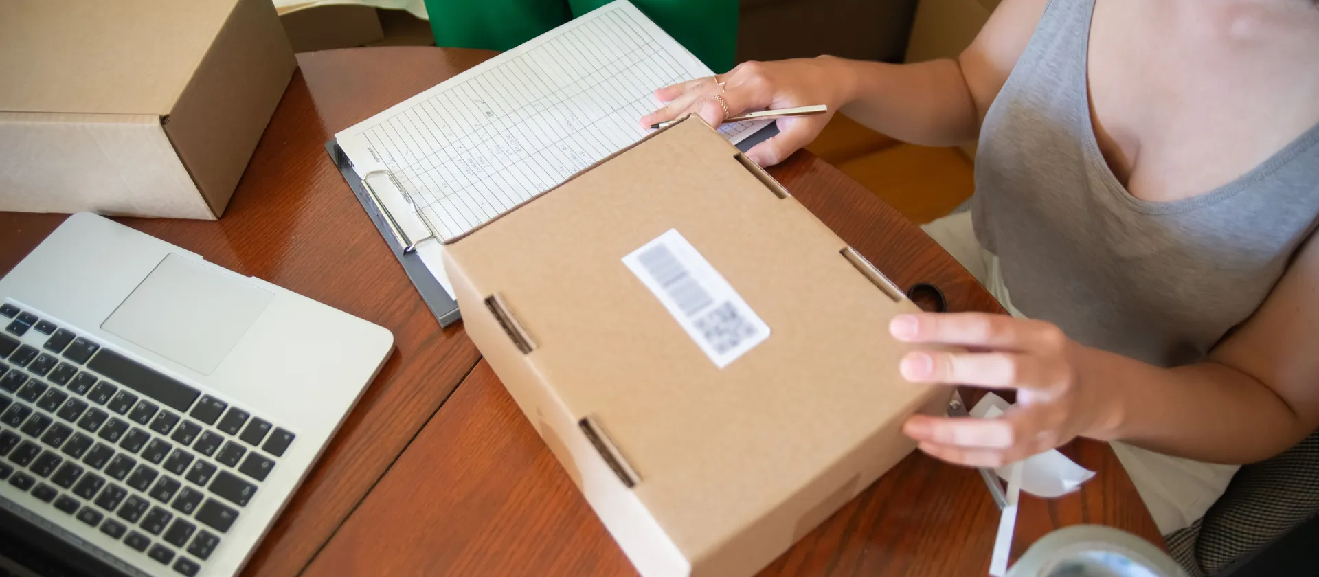 A small-business owner preparing a parcel for fulfilment.