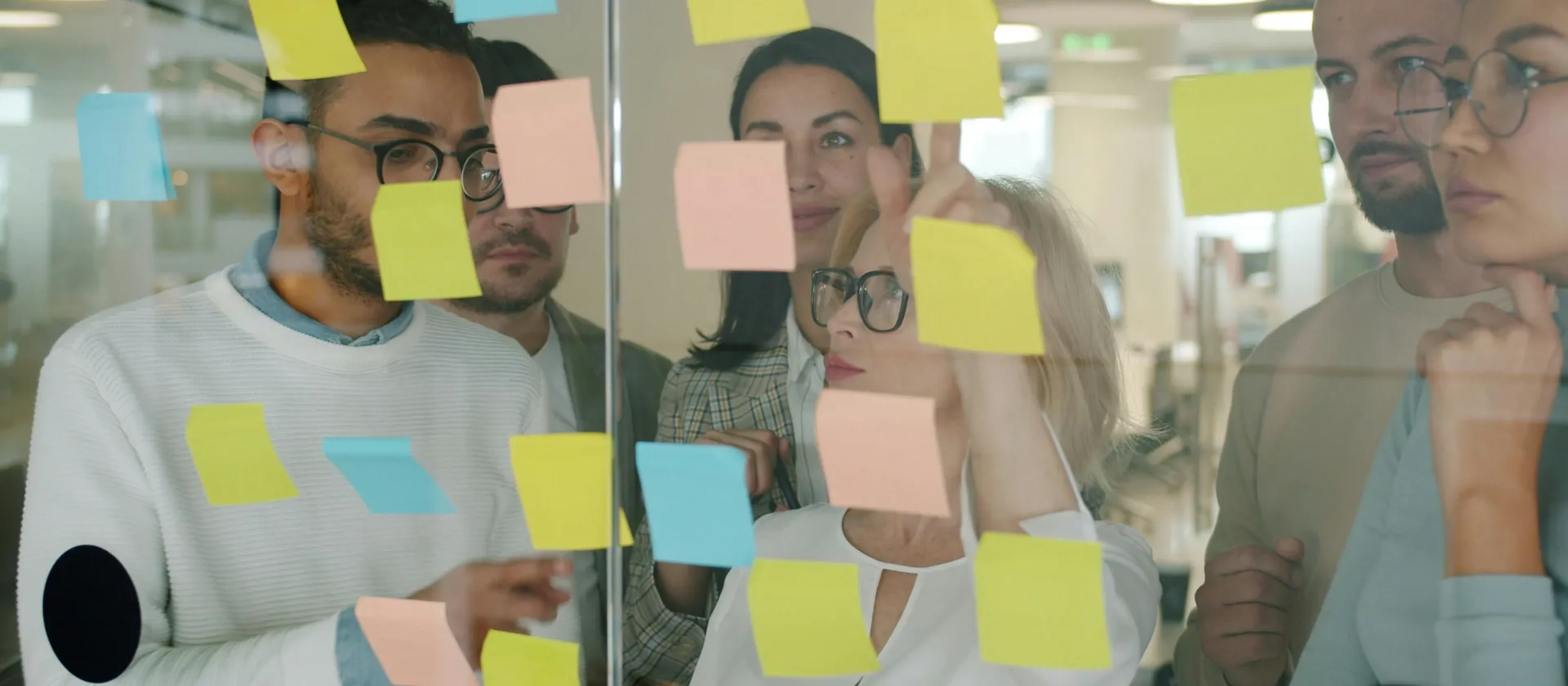 People reviewing sticky-note decisions in a strategy workshop.