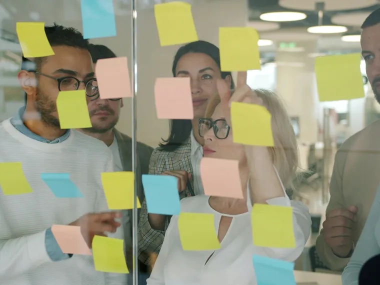 People reviewing sticky-note decisions in a strategy workshop.